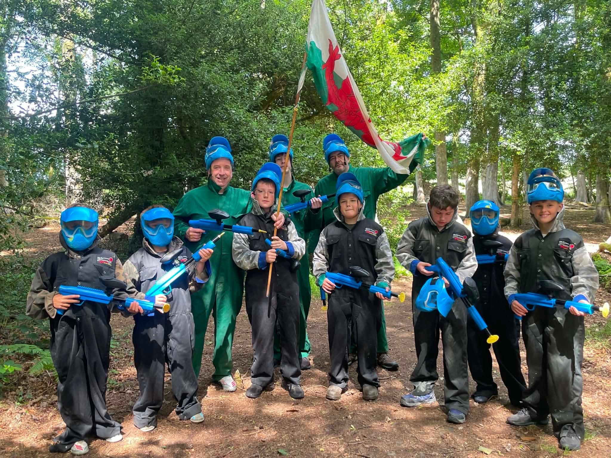 Children playing low-impact paintball with a flag at Paintball Wales